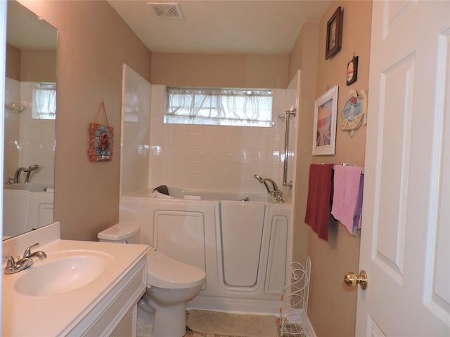 bathroom with vanity, a bathtub, and toilet