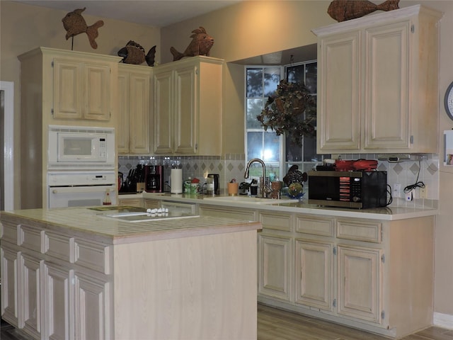 kitchen featuring decorative backsplash, white appliances, sink, and a kitchen island