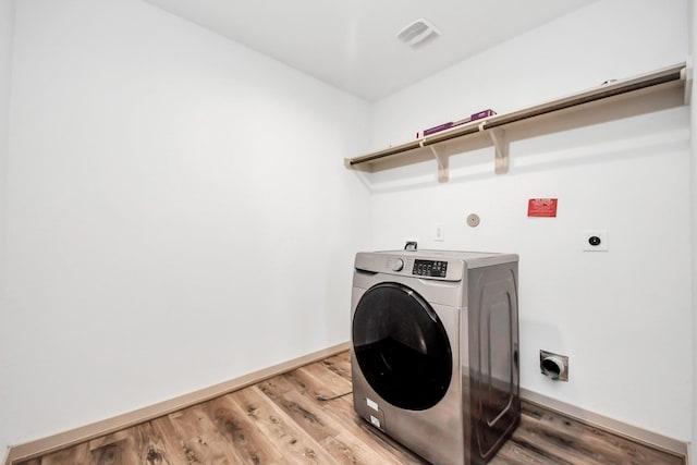 laundry area featuring hardwood / wood-style flooring and washer / dryer