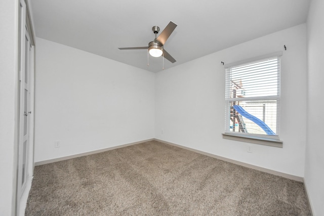 carpeted spare room featuring ceiling fan