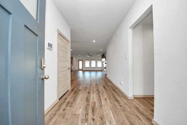 hallway with light hardwood / wood-style floors