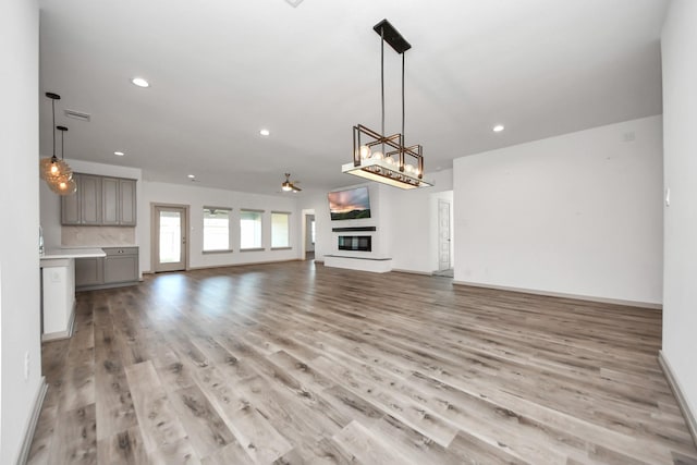 unfurnished living room featuring ceiling fan and light hardwood / wood-style flooring