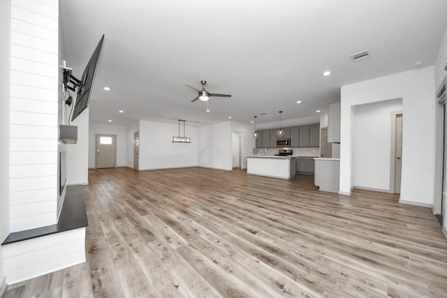 unfurnished living room with light hardwood / wood-style floors and ceiling fan