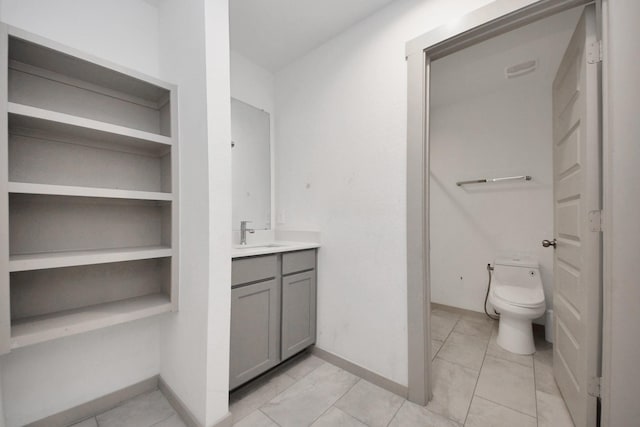 bathroom with vanity, built in features, and toilet