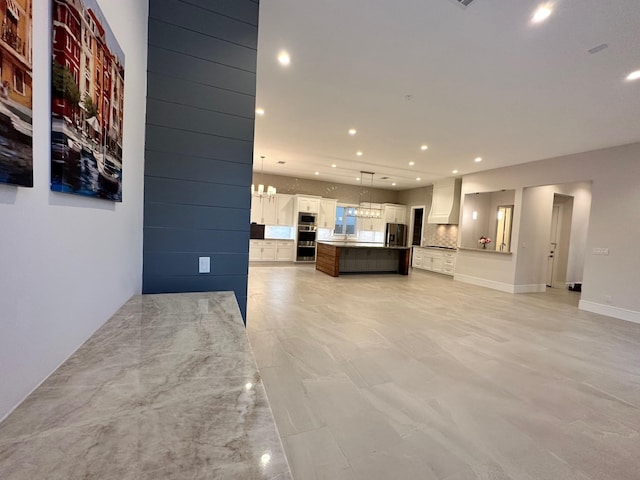 unfurnished living room with an inviting chandelier