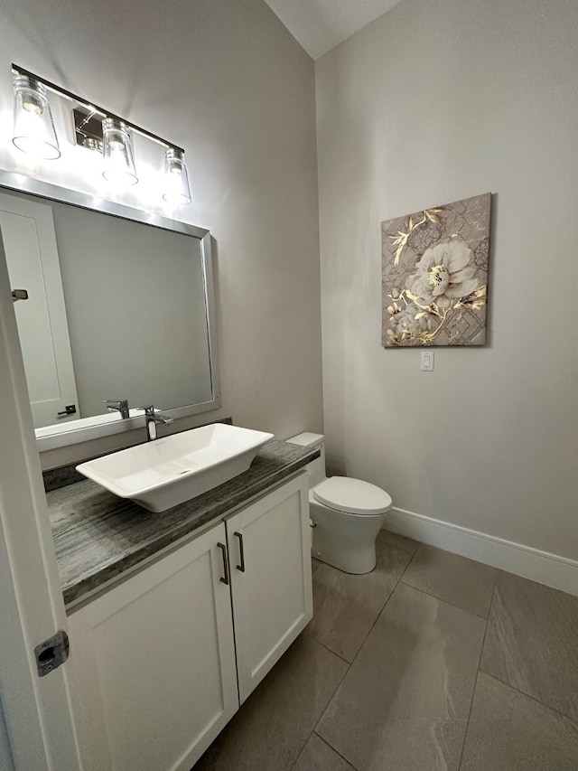 bathroom featuring tile patterned flooring, vanity, and toilet