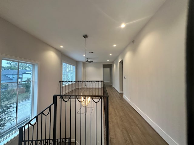 hallway featuring dark wood-type flooring and an inviting chandelier