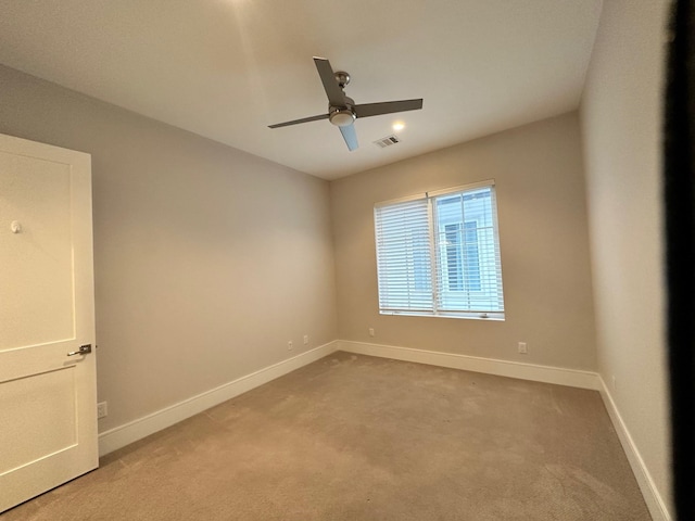 spare room featuring light carpet and ceiling fan