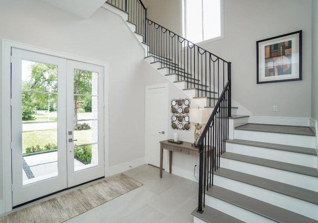 foyer entrance with a towering ceiling and french doors