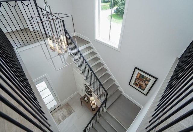 staircase with a notable chandelier