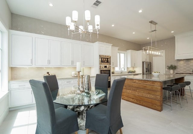 dining area featuring an inviting chandelier and sink