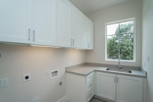 laundry area featuring electric dryer hookup, sink, hookup for a washing machine, and cabinets