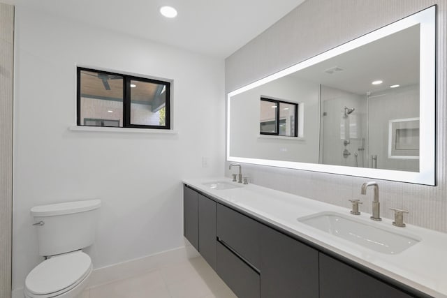 bathroom with vanity, toilet, tile patterned floors, and walk in shower