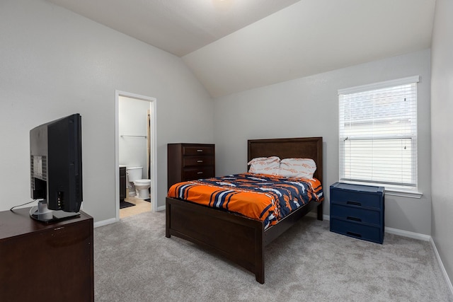 carpeted bedroom with vaulted ceiling and connected bathroom