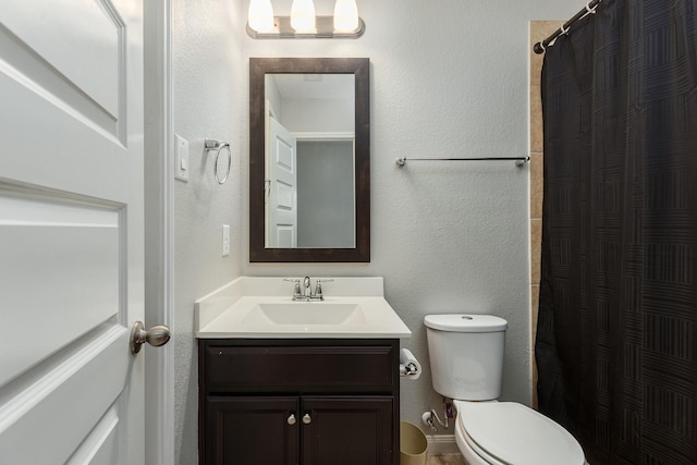 bathroom featuring vanity, toilet, and walk in shower