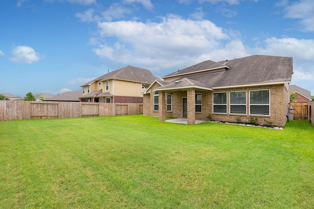 back of property with a yard and a patio