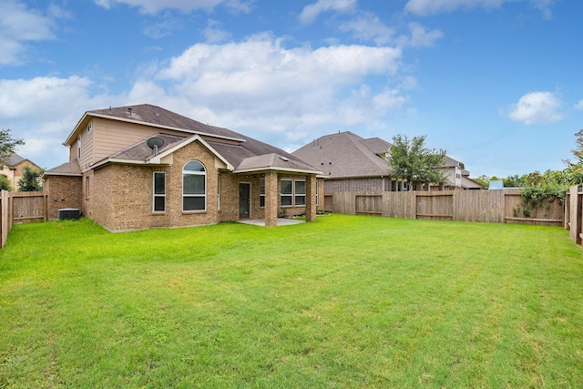 rear view of property with a yard and central AC unit