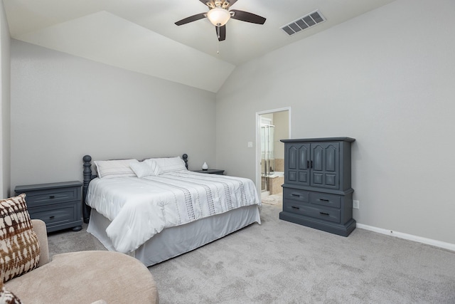 bedroom featuring vaulted ceiling, light colored carpet, ceiling fan, and ensuite bath