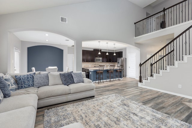 living room with hardwood / wood-style flooring and a high ceiling