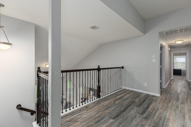 corridor with dark wood-type flooring and lofted ceiling