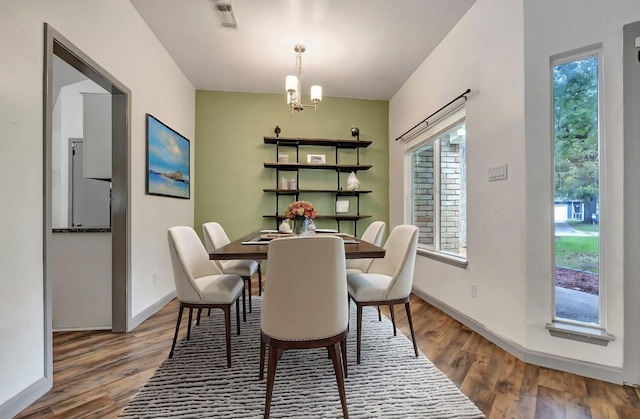 dining space with an inviting chandelier and wood-type flooring