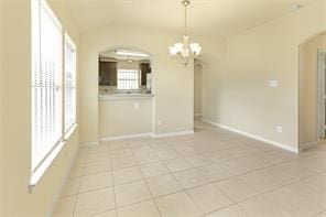 unfurnished dining area with a notable chandelier