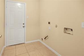 washroom with hookup for a gas dryer, light tile patterned flooring, and hookup for an electric dryer