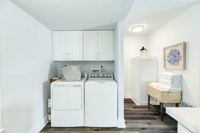 washroom featuring independent washer and dryer, dark wood-type flooring, and cabinets