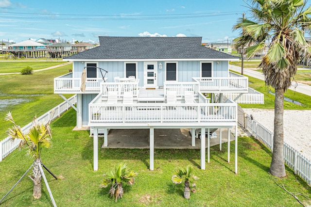 rear view of property featuring a wooden deck and a lawn