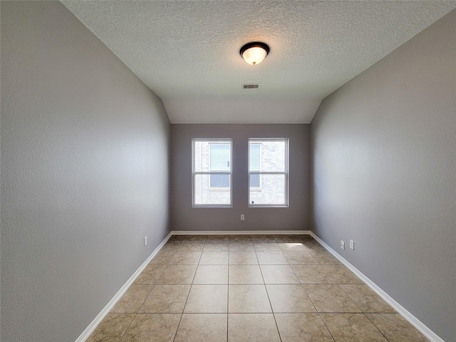 spare room with light tile patterned floors and a textured ceiling