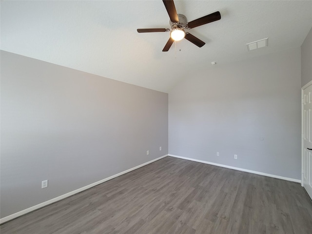 spare room with dark hardwood / wood-style flooring, vaulted ceiling, and ceiling fan