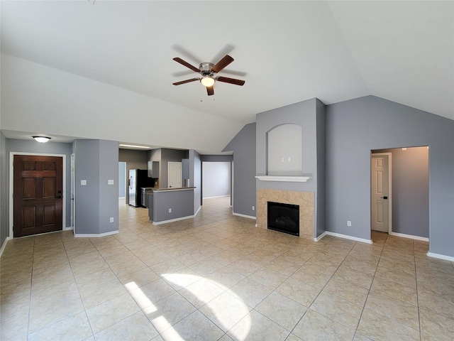 unfurnished living room featuring ceiling fan, lofted ceiling, light tile patterned flooring, and a fireplace