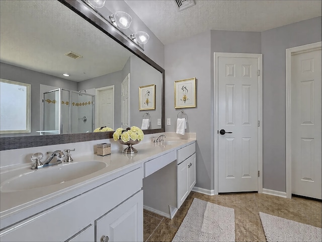 bathroom with walk in shower, vanity, tile patterned flooring, and a textured ceiling