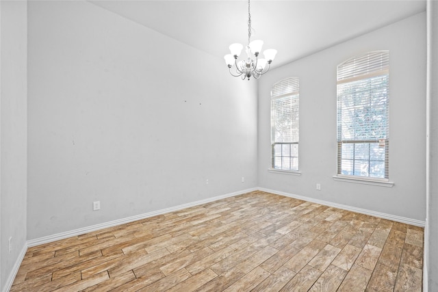 empty room with an inviting chandelier and light hardwood / wood-style floors