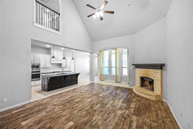 kitchen with light hardwood / wood-style flooring, ceiling fan, appliances with stainless steel finishes, white cabinets, and a kitchen island