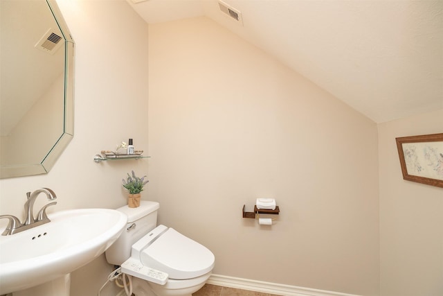 bathroom with vaulted ceiling, sink, and toilet