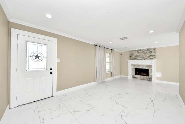 foyer entrance with crown molding and a fireplace