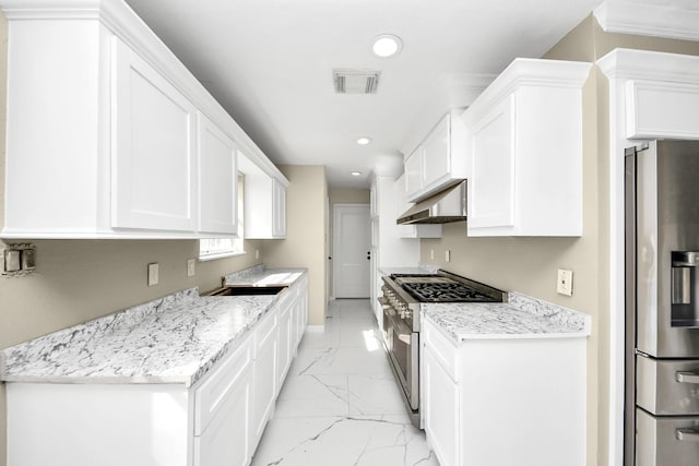 kitchen featuring stainless steel appliances, white cabinetry, light stone countertops, and range hood