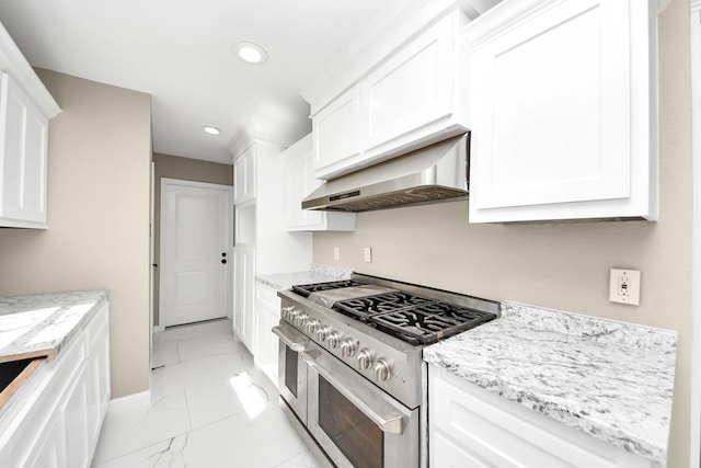 kitchen with white cabinetry, double oven range, light stone counters, and wall chimney range hood