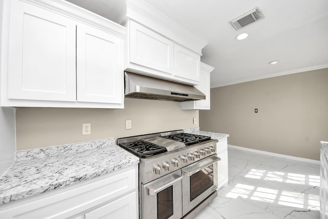 kitchen featuring range with two ovens, extractor fan, light stone countertops, and white cabinets