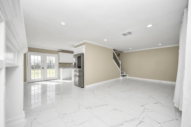 unfurnished living room with ornamental molding and french doors