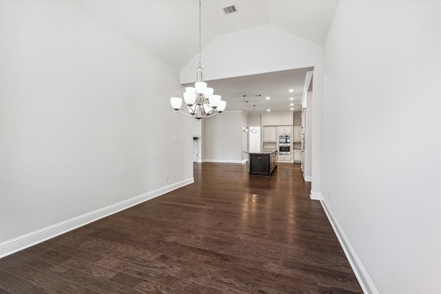 unfurnished dining area featuring dark hardwood / wood-style flooring, vaulted ceiling, and an inviting chandelier