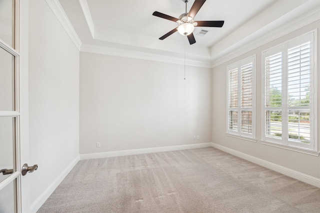 carpeted spare room with crown molding, ceiling fan, and a tray ceiling