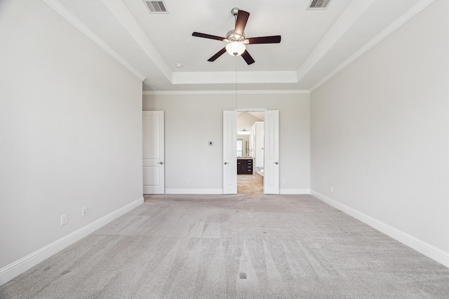 unfurnished bedroom with crown molding, ceiling fan, a raised ceiling, and light carpet