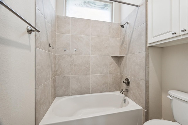 bathroom featuring tiled shower / bath and toilet