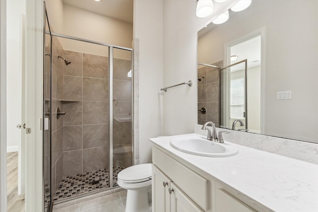 bathroom featuring tile patterned floors, vanity, toilet, and an enclosed shower