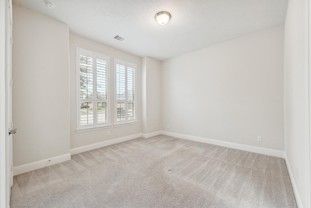 spare room featuring light carpet