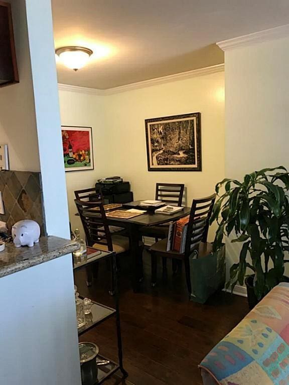 dining room featuring dark hardwood / wood-style flooring and crown molding