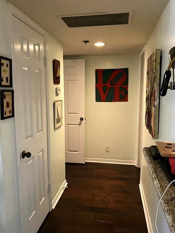 corridor with dark hardwood / wood-style flooring