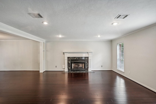 unfurnished living room featuring dark wood-type flooring, a fireplace, and a textured ceiling